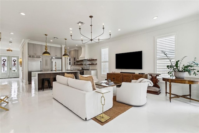 living room featuring a notable chandelier, ornamental molding, and sink