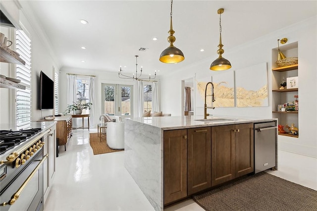 kitchen featuring sink, decorative light fixtures, ornamental molding, an island with sink, and light stone countertops