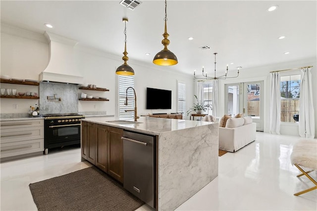 kitchen featuring high end black range oven, sink, hanging light fixtures, custom range hood, and light stone countertops