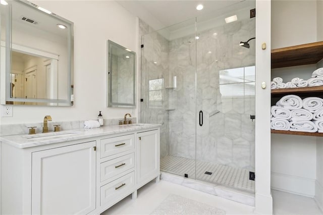 bathroom with vanity and a shower with door