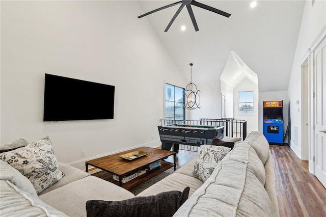 living room featuring hardwood / wood-style floors, ceiling fan with notable chandelier, and high vaulted ceiling