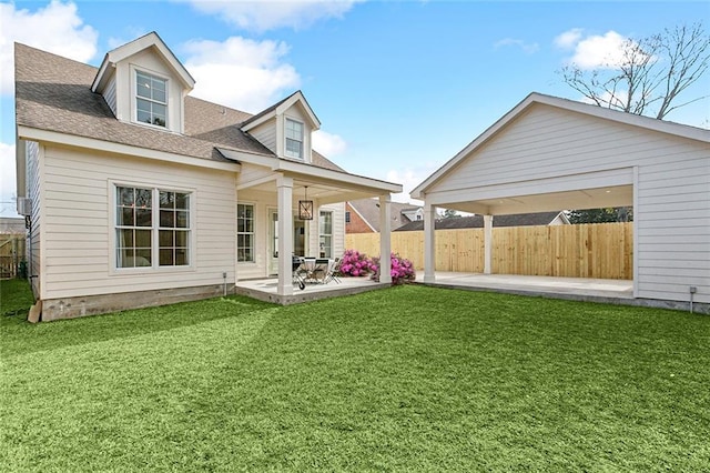 rear view of house featuring a yard and a patio