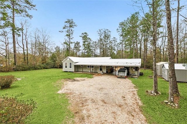 ranch-style home featuring a carport, a shed, and a front lawn