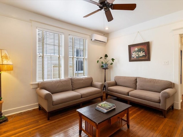 living area featuring an AC wall unit, ceiling fan, baseboards, and hardwood / wood-style flooring