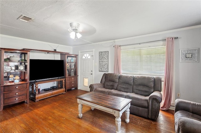 living room with crown molding, ceiling fan, dark hardwood / wood-style floors, and a textured ceiling