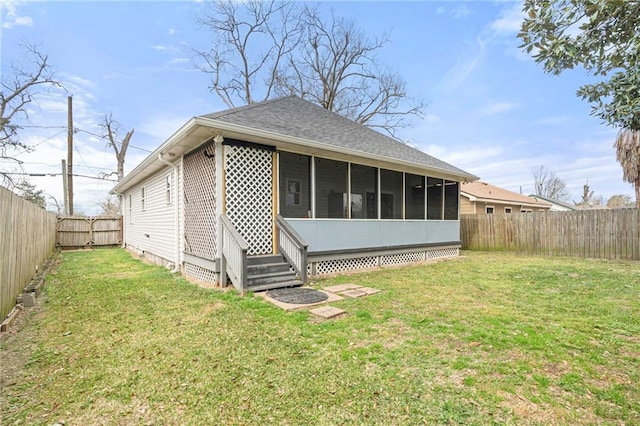 rear view of house with a lawn and a sunroom