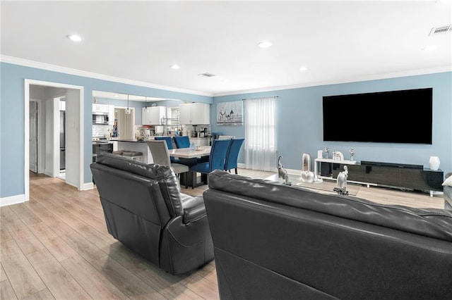 living room featuring crown molding and light hardwood / wood-style floors