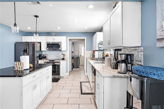 kitchen featuring white cabinetry, light tile patterned floors, stainless steel appliances, and dark stone countertops