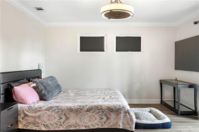 bedroom with crown molding and light hardwood / wood-style flooring