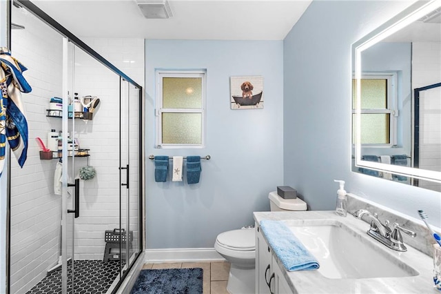 bathroom with vanity, a shower with shower door, tile patterned floors, and toilet