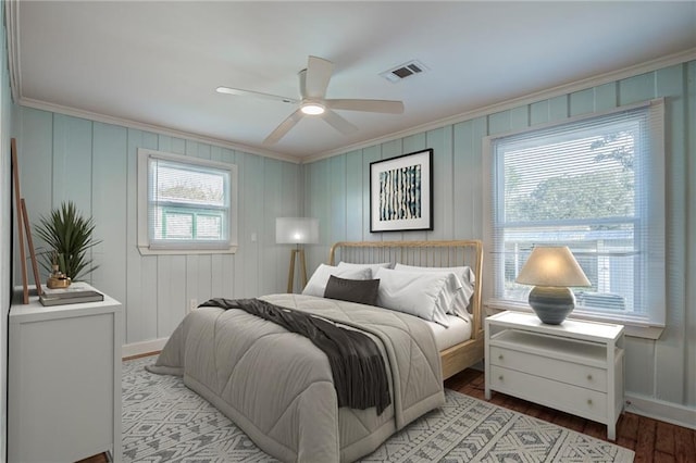 bedroom featuring multiple windows, crown molding, ceiling fan, and light wood-type flooring