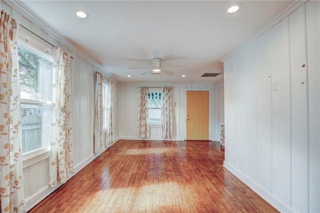 spare room with hardwood / wood-style flooring, ceiling fan, and crown molding