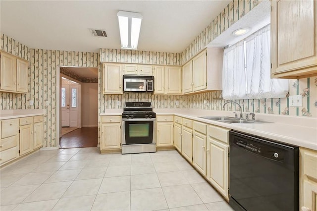 kitchen with sink, light tile patterned floors, and appliances with stainless steel finishes