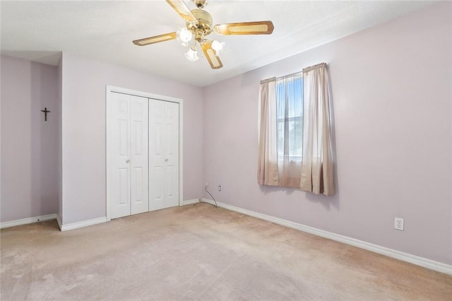 unfurnished bedroom with ceiling fan, light colored carpet, and a closet