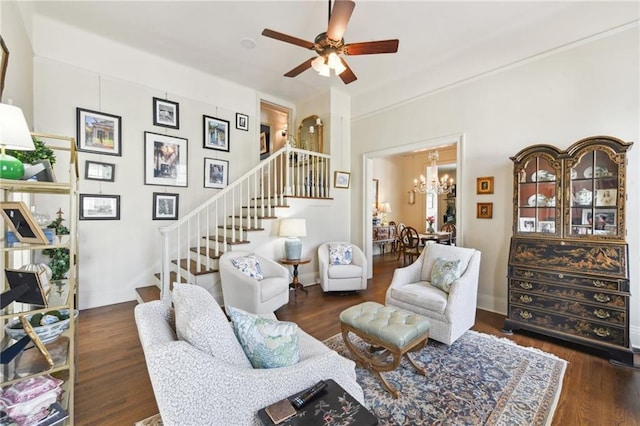 living room with ceiling fan with notable chandelier and dark wood-type flooring