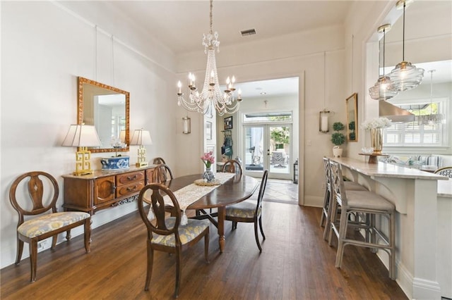 dining area featuring dark hardwood / wood-style floors, a notable chandelier, and french doors