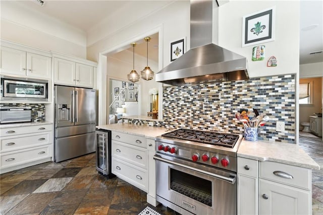 kitchen featuring high quality appliances, white cabinetry, beverage cooler, and wall chimney exhaust hood