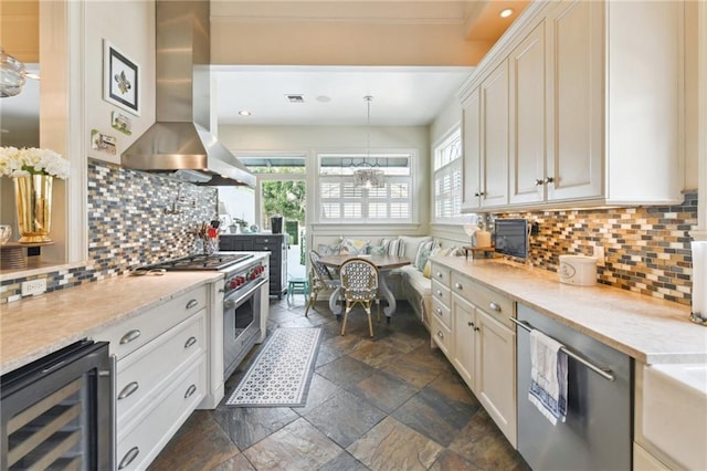 kitchen featuring appliances with stainless steel finishes, white cabinetry, beverage cooler, hanging light fixtures, and island exhaust hood