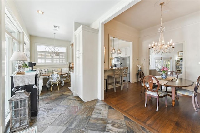 dining space with dark hardwood / wood-style flooring, a notable chandelier, and a healthy amount of sunlight