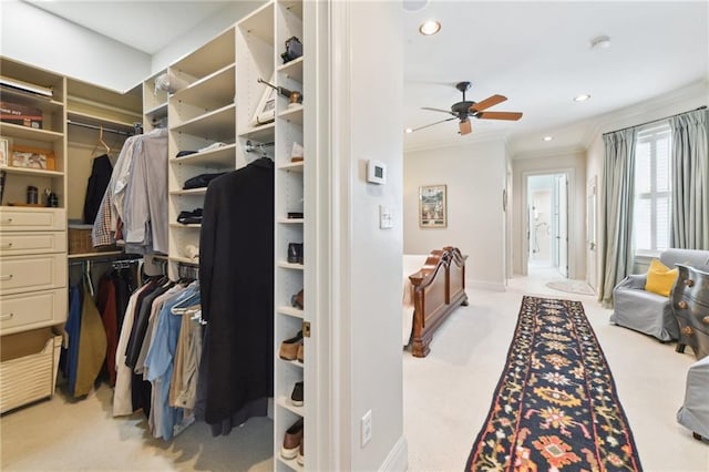 walk in closet featuring light colored carpet and ceiling fan