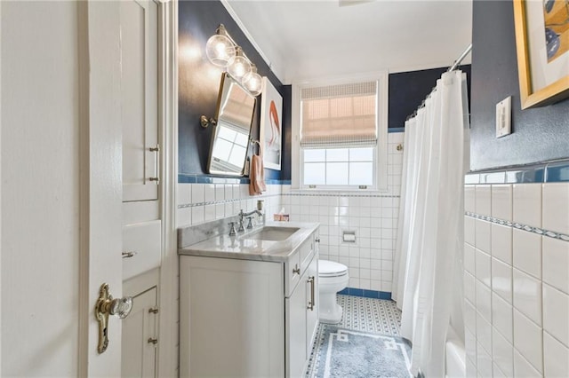 bathroom featuring vanity, tile walls, and toilet