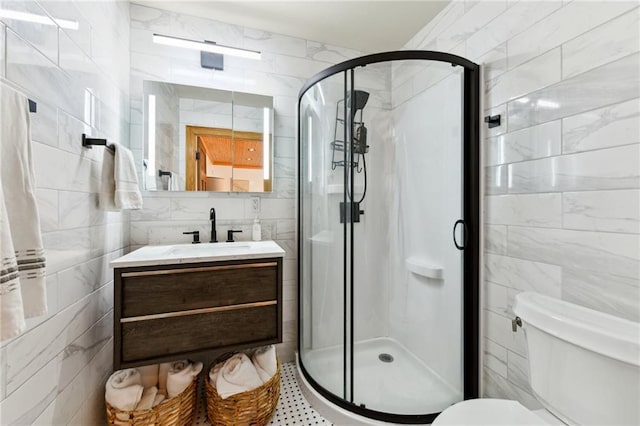 bathroom with walk in shower, vanity, toilet, and tile walls