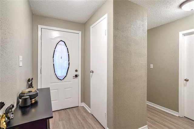 entryway featuring a textured ceiling and light wood-type flooring