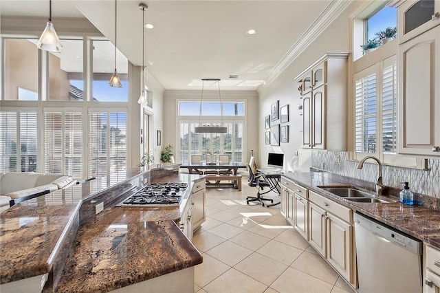 kitchen featuring a sink, dark stone counters, appliances with stainless steel finishes, crown molding, and light tile patterned floors