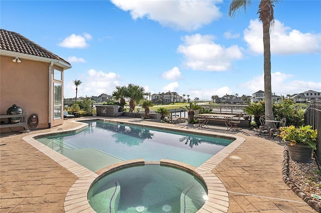 view of pool with a patio and a pool with connected hot tub