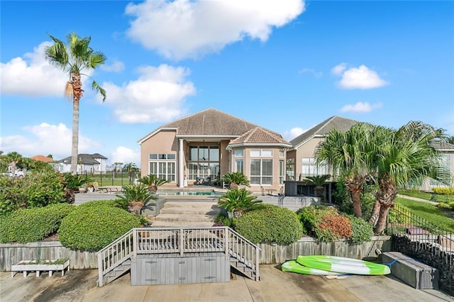 back of house featuring a patio, fence, a fenced in pool, stucco siding, and stairs