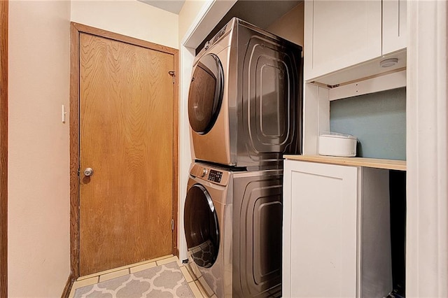 laundry room with stacked washer and dryer and cabinets