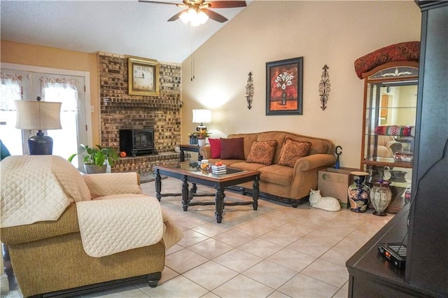 living room featuring vaulted ceiling, a wood stove, ceiling fan, and light tile patterned flooring