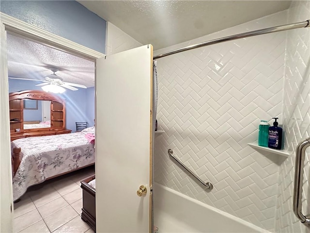 bathroom featuring ceiling fan, tile patterned floors, tiled shower / bath combo, and a textured ceiling