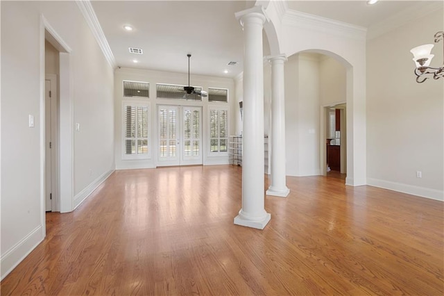 unfurnished living room with light wood-type flooring, ceiling fan, and ornate columns