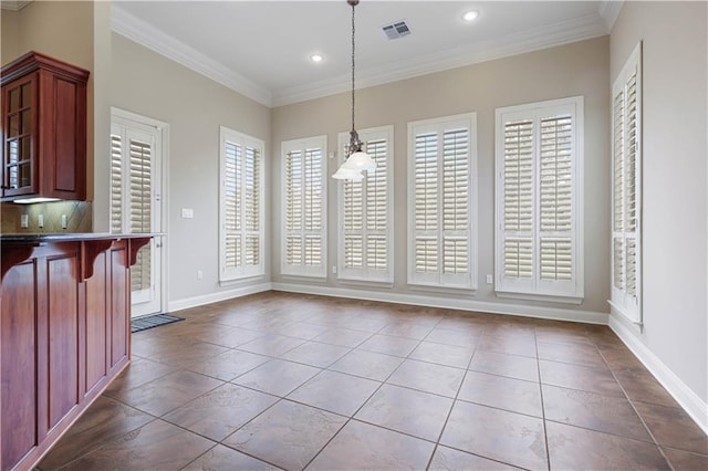 dining space featuring crown molding and tile patterned floors