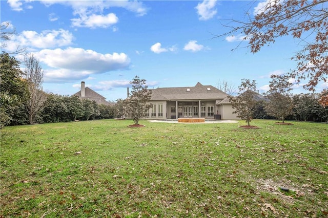 back of property with french doors, a yard, a sunroom, and a patio