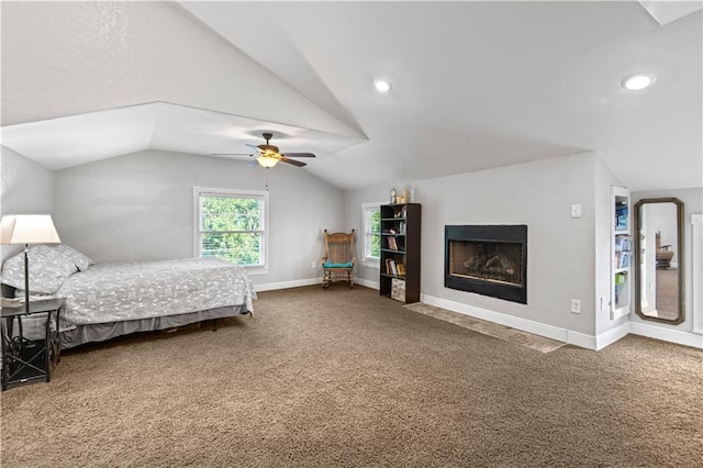 carpeted bedroom with a fireplace with flush hearth, recessed lighting, baseboards, ceiling fan, and vaulted ceiling