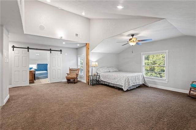 bedroom featuring visible vents, lofted ceiling, a barn door, carpet flooring, and baseboards