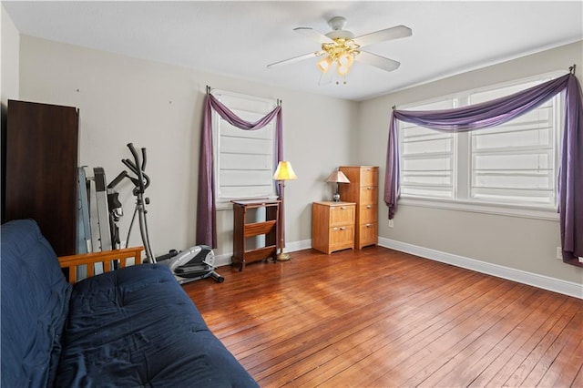 bedroom featuring baseboards, wood-type flooring, and ceiling fan