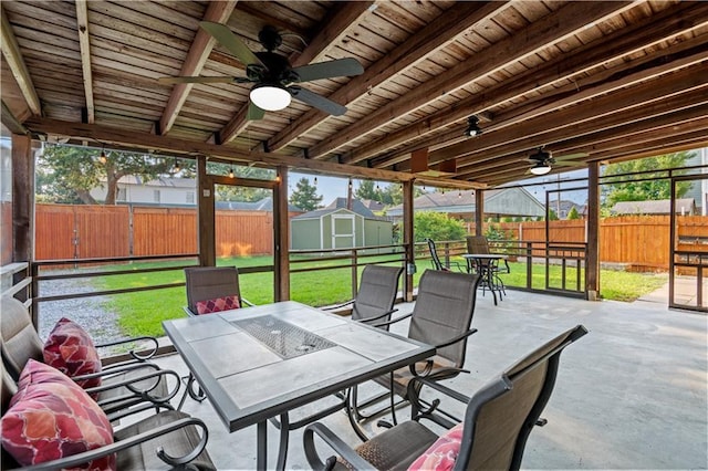 exterior space with an outbuilding, outdoor dining space, a ceiling fan, a fenced backyard, and a storage shed