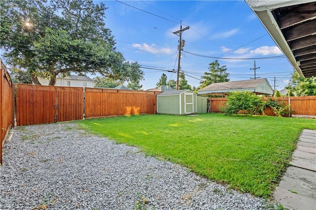 view of yard featuring an outbuilding, a storage shed, and a fenced backyard