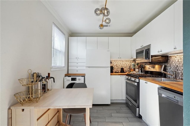 kitchen featuring backsplash, stainless steel appliances, washer / dryer, and white cabinets