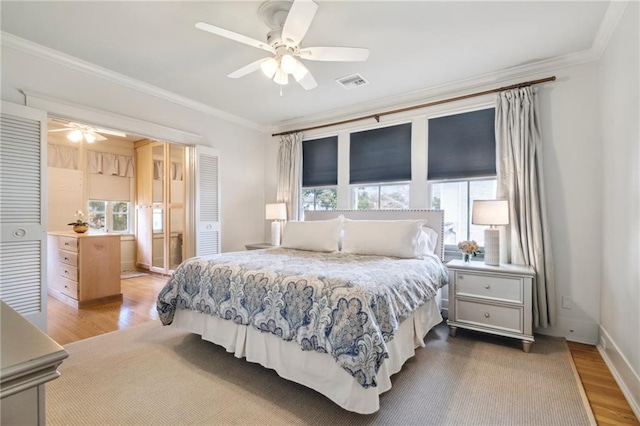 bedroom featuring ceiling fan, ornamental molding, and wood-type flooring