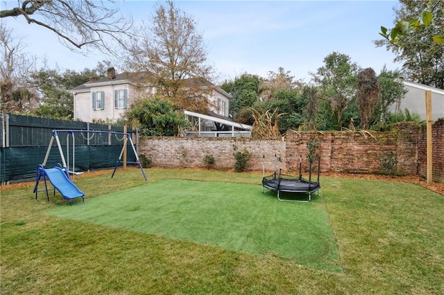 view of yard with a playground and a trampoline