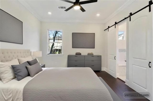 bedroom with dark hardwood / wood-style floors, ceiling fan, crown molding, a barn door, and ensuite bath