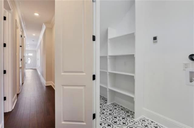 hall with crown molding, a barn door, and dark wood-type flooring