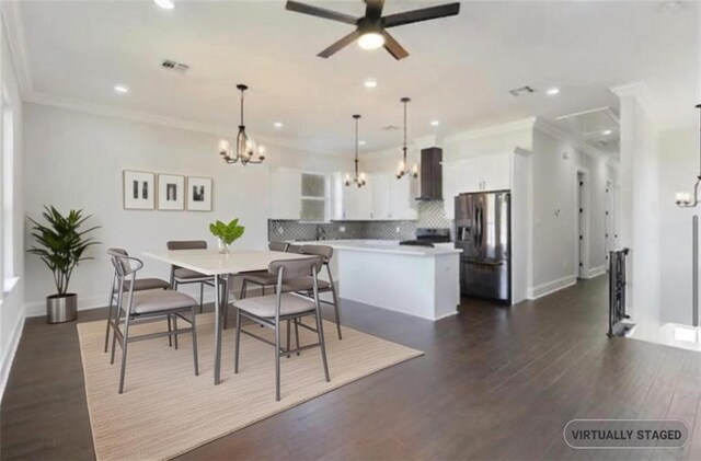 dining space featuring ceiling fan with notable chandelier, ornamental molding, and dark hardwood / wood-style floors