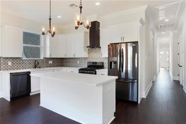 kitchen featuring white cabinetry, appliances with stainless steel finishes, a center island, and wall chimney range hood