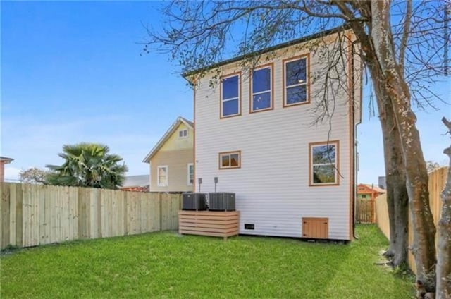 back of house featuring cooling unit and a yard