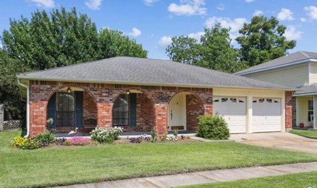 view of front of house featuring a garage, a porch, and a front yard